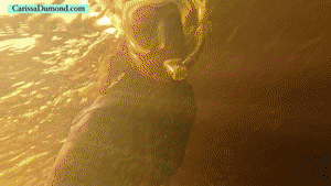 xsiteability.com - Carissa in vintage wetsuit at edge of a clear spring and the dark river  thumbnail